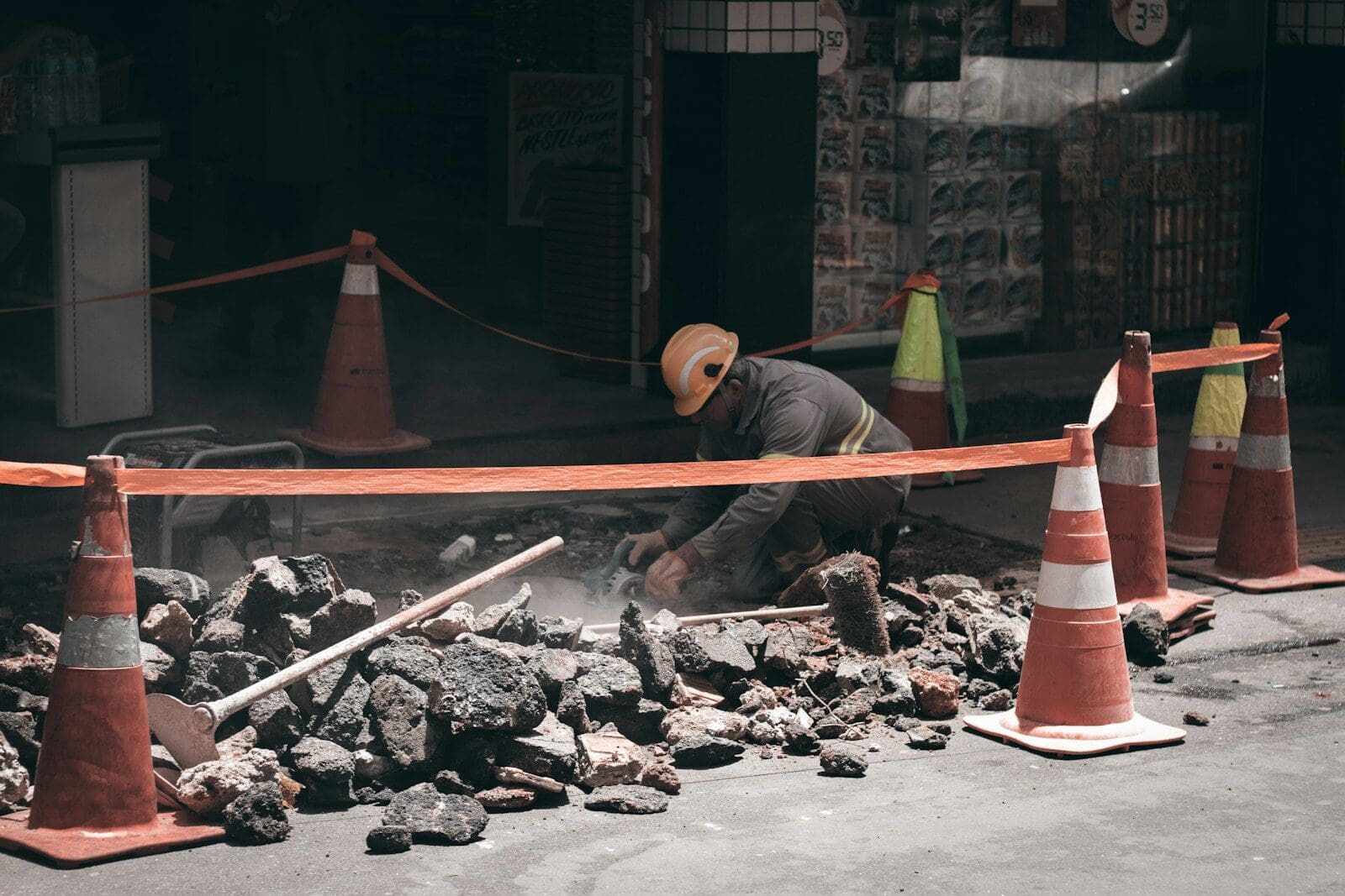 man in yellow t-shirt sitting on red and white traffic cone